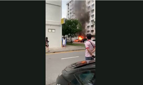 新加坡组屋区停车场的货车突然起火，路人争相拍照
