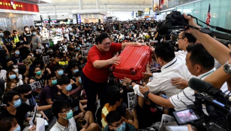 在香港机场高举红色行李箱、越过大批示威者的“红衣女”竟是新加坡人！她到底经历了啥