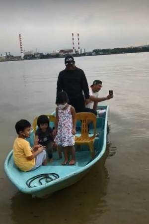 妈妈带着子女乘小船  到柔佛海峡遥望爸爸